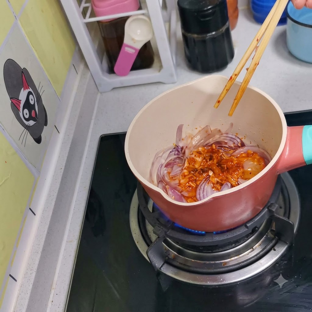 Kimchi et oignons rouges mélangés ensemble dans la casserole à laide de baguettes en bois.