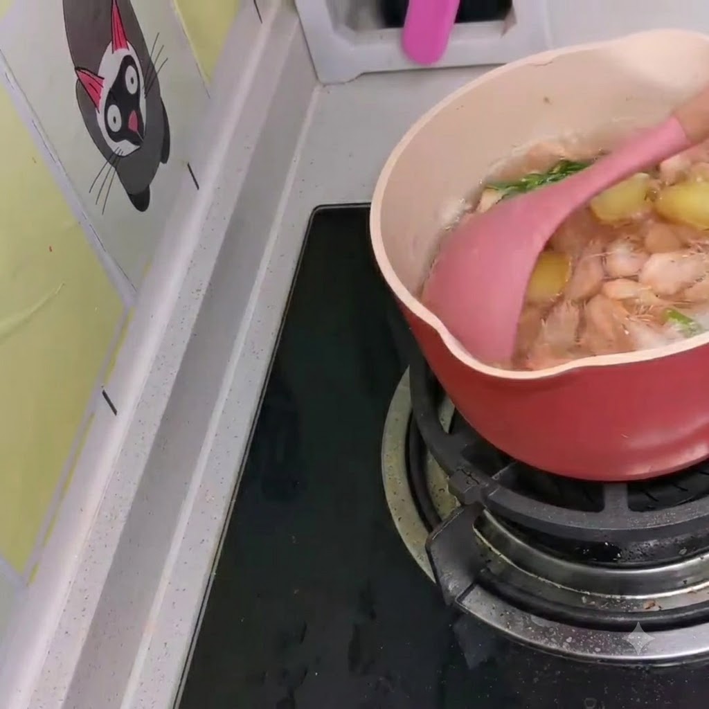 De petites crevettes blanches incorporées dans une casserole de ramen de style coréen en train de mijoter à laide dune spatule rose.