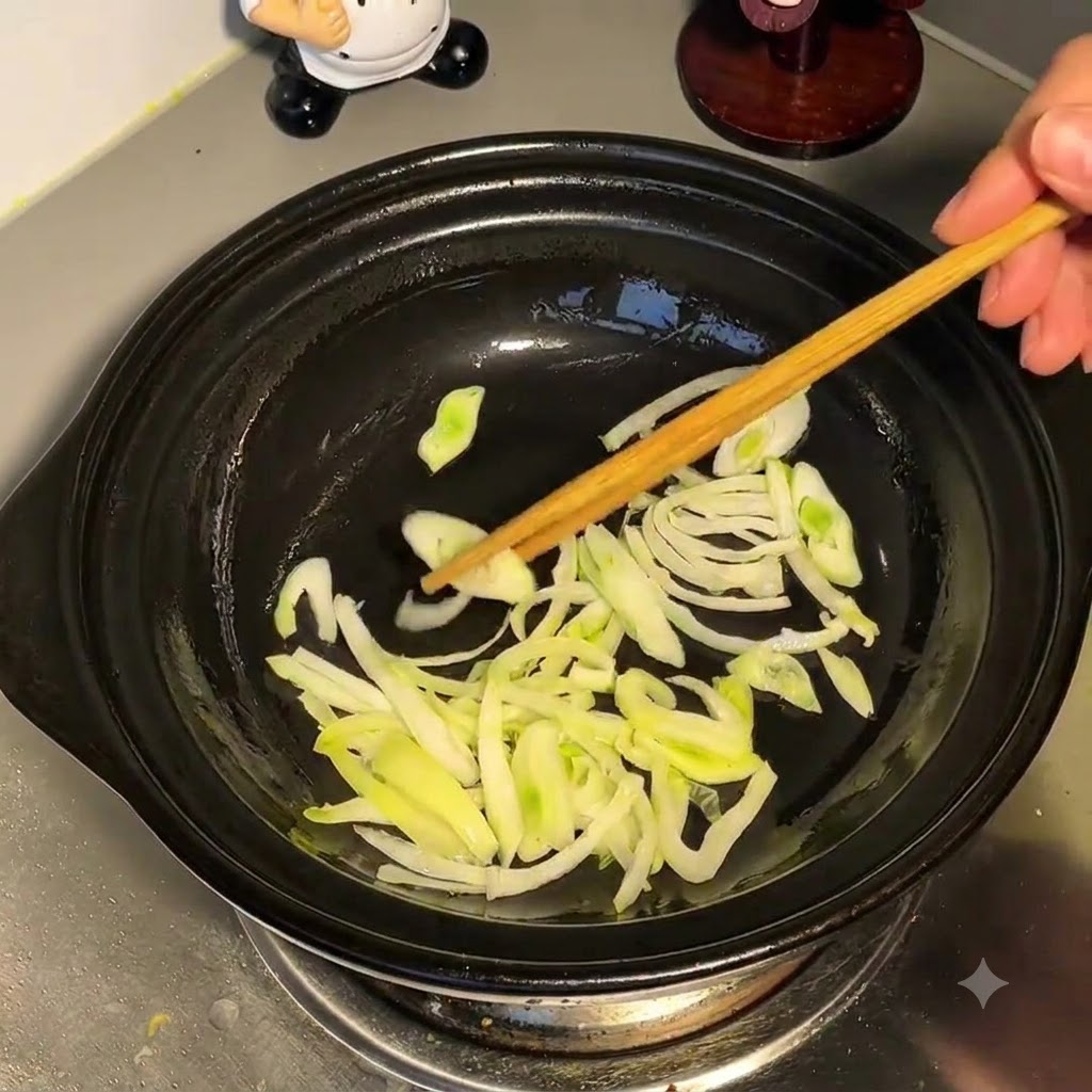 De leau versée par le dessus dans une marmite contenant des oignons verts sautés.