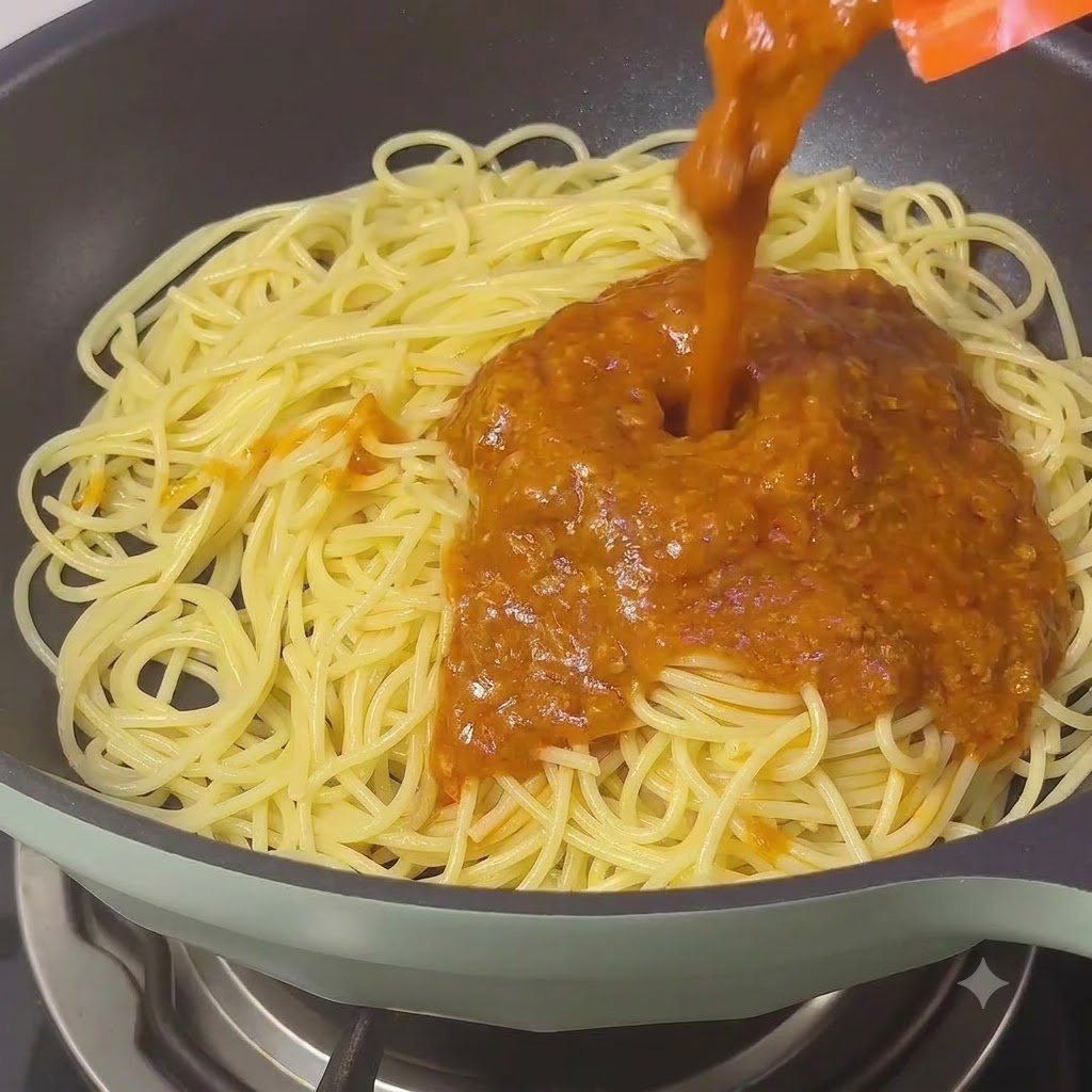 Une riche sauce bolognaise classique versée sur les spaghettis dans une poêle.