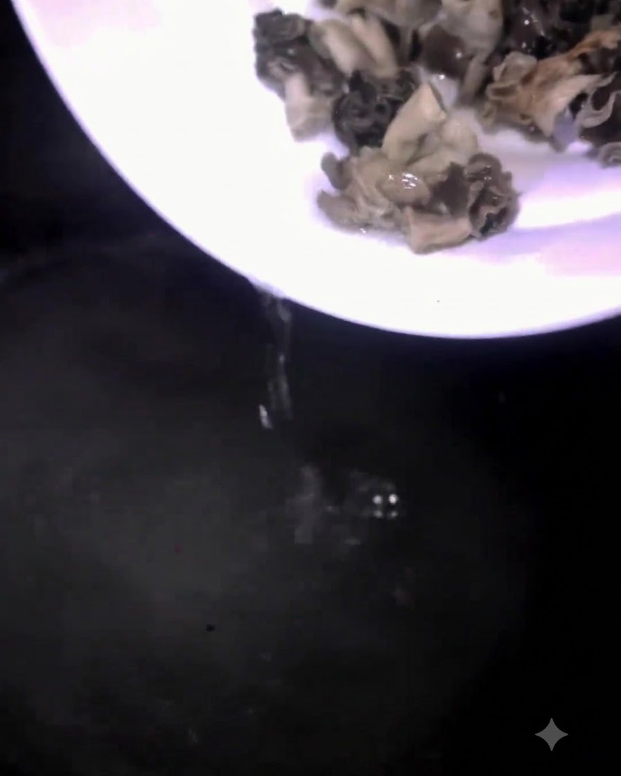 Des champignons versés depuis une assiette blanche dans une casserole deau bouillante.