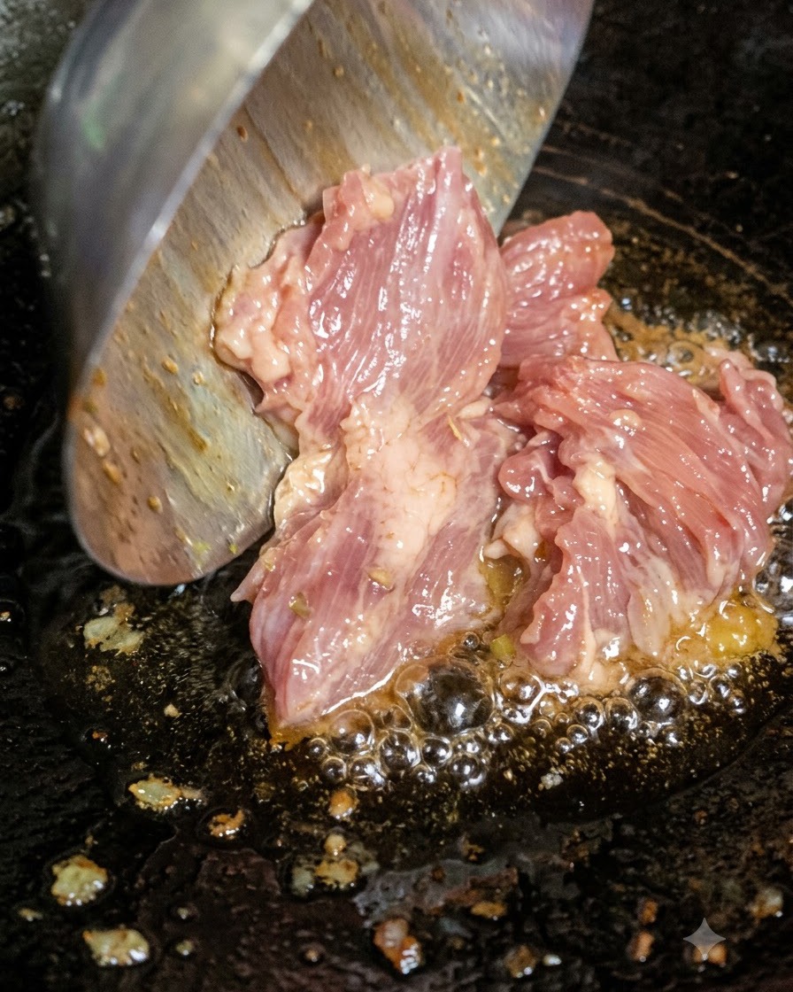 De la viande hachée crue ajoutée à laide dune louche dans de lhuile chaude bouillante dans un wok.