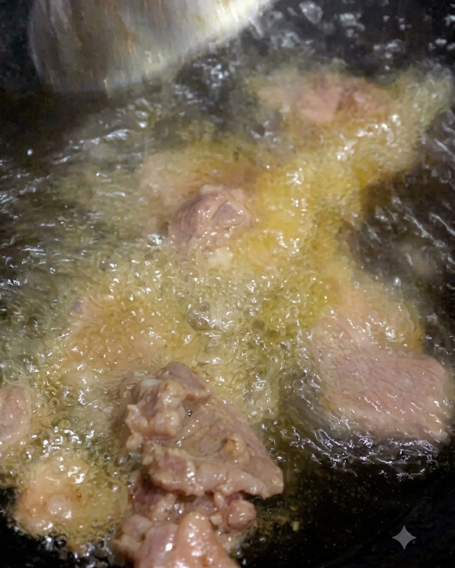 De la viande cuisant dans lhuile chaude avec des assaisonnements qui bullent dans la poêle.