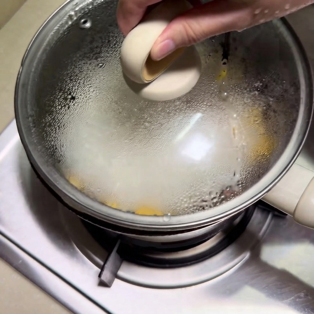 Un couvercle en verre transparent placé sur la cocotte, emprisonnant la vapeur à lintérieur.
