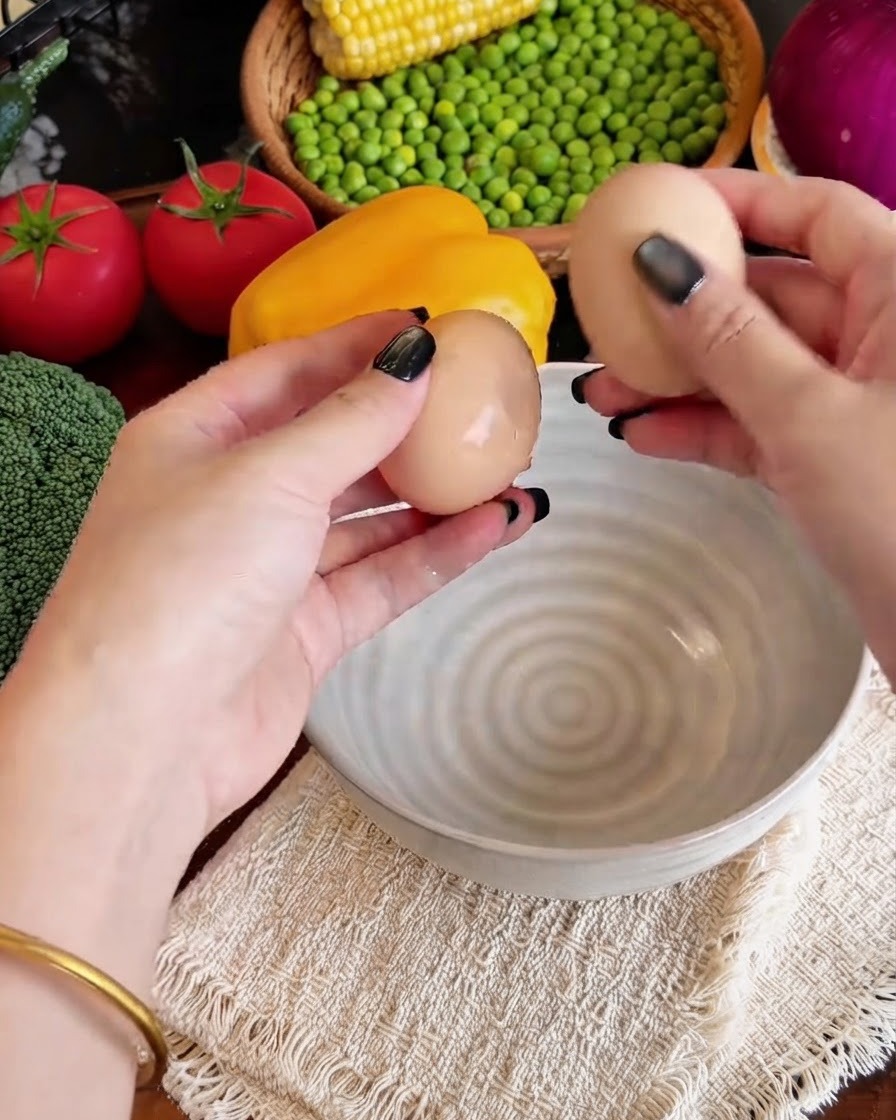 Œufs cassés dans un bol avec des bâtonnets de surimi effilochés et du lait.