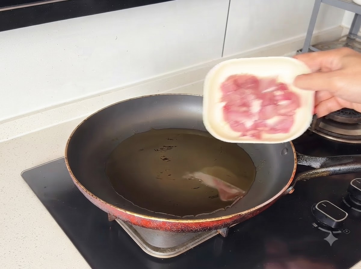 Des morceaux de porc qui grésillent dans de lhuile chaude à lintérieur dune poêle.