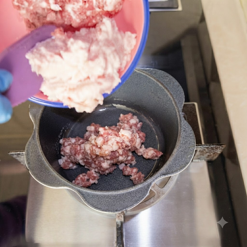 Du porc haché versé dans une petite casserole sur la cuisinière.