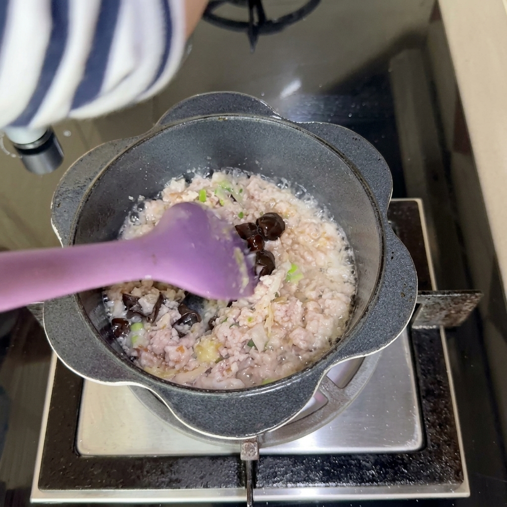 De la pâte de soja douce foncée mélangée à la viande en train de cuire.